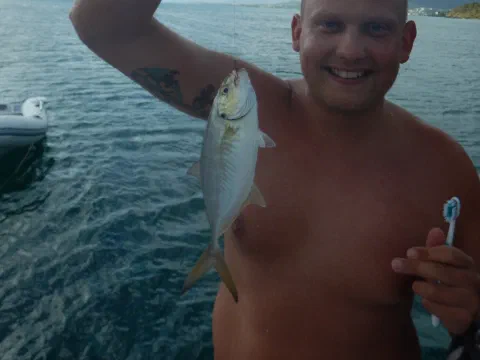 Stolt Tobias med fisk fanget på tandbørste og fiskeline